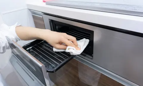 Professional maid cleaning oven during a kitchen deep cleaning service
